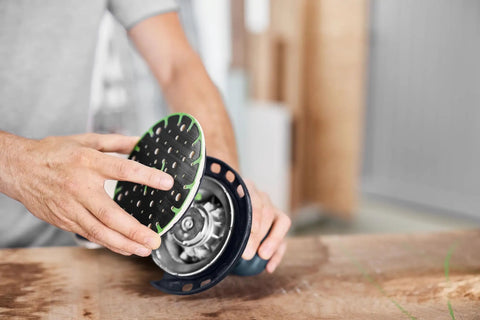 Person fixing Soft Sanding Pad For 150mm Sanders With High Temperature Durability For Heavy Duty Jobs Universal Fit For Flat And Contoured Surfaces