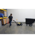 Heavy Duty Electric Powered Tugger 3K Cart Mover for Airports and Warehouses in use, dragging a trailer in a warehouse.