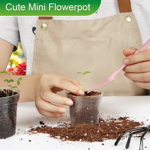 Person planting seedling in clear mini flowerpot with soil, wearing apron; focus on Clear 2.5 Inch Nursery Pots Set Of 50 With Drainage Holes Durable Plastic Seed Starter Pots For Seedlings Veggies And Flowers Translucent Plant Pots For Easy Root Observation Great Gardening Gift.