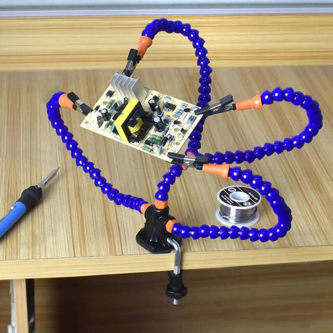 No Sweat Hella Solid Third Hand Soldering Helper With Four Bendable Upright Arms supporting a circuit board on a worktable.