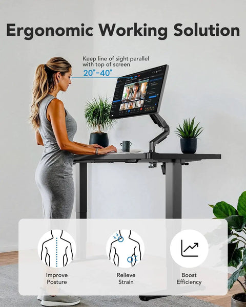 User adjusting Huanuo 70x35 Inch Electric Standing Desk With Three Stage Brushless Motor Black for ergonomic use.