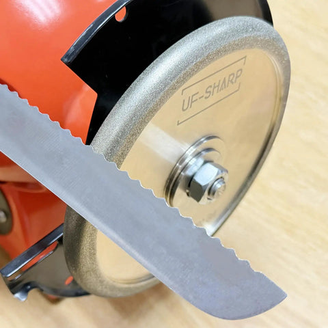 Close-up of Knockout Heavy Duty 6 Inch Diamond Serration Grinding Wheel, section of serrated knife, stainless adapter visible.
