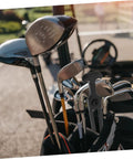 Golf clubs in a bag with blurred golf course and cart in background