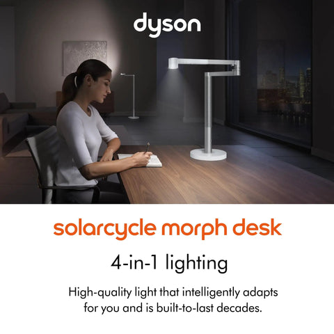 Woman writing under Solarcycle Morph Desk Light With Adaptive Daylight Tracking, showing sleek design in a dimly lit room.