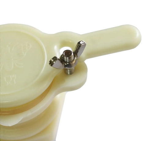 Close-up of food-grade plastic honey gate tap valve with tighten screw for beekeeping systems