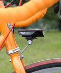 Center Fork Headlight Bracket for Bikes with headlight attached, mounted on orange bike fork, showcasing adjustable beam angle.