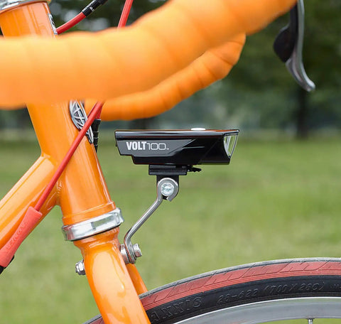 Center Fork Headlight Bracket for Bikes with headlight attached, mounted on orange bike fork, showcasing adjustable beam angle.
