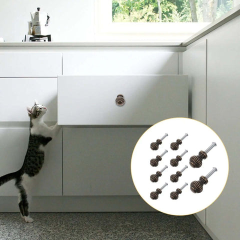 A cat reaches for a cabinet with Vintage Bronze Cabinet Drawer Handles 10 Pack Alloy Door Pulls for furniture and wardrobe.
