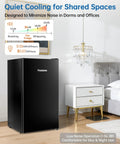 Frostorm 3.2 cu ft black mini fridge with freezer; single-door unit placed in a bedroom beside a white nightstand.