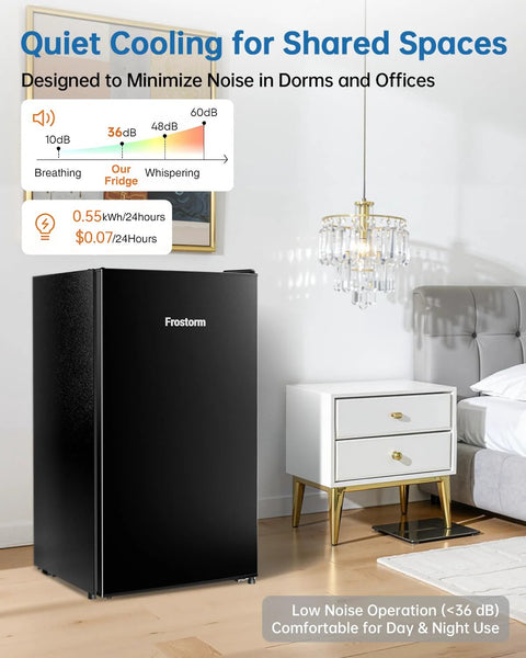 Frostorm 3.2 cu ft black mini fridge with freezer; single-door unit placed in a bedroom beside a white nightstand.