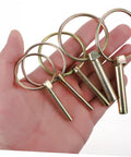 Hand holding Beefy 10 Pack Heavy Duty Lynch Pin Kit With Spring Loaded Quick Disconnect Rings for trailer hitch applications