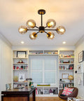 Lit Six Light Black Glass Globe Chandelier For Living Room And Kitchen Island in a modern farmhouse style office space.