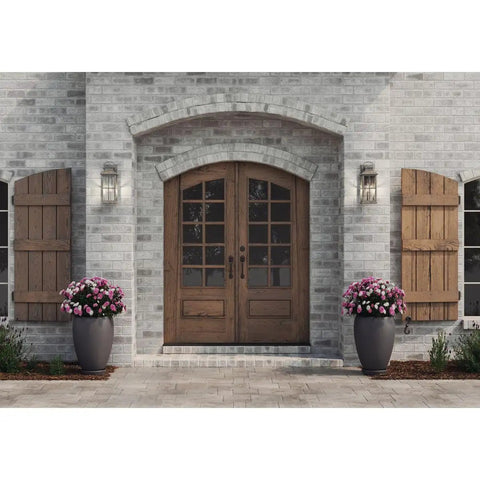 Williamston Collection One Light Outdoor Wall Lantern in Antique Pewter Finish mounted on house facade beside wooden doors.