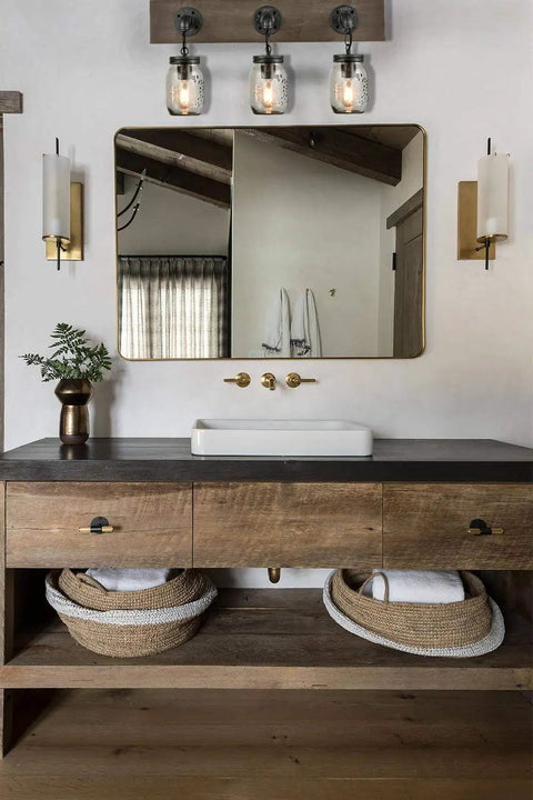 Farmhouse Style 3-Light Mason Jar Wall Sconce With Wood Base And Glass Shades in modern bathroom vanity lighting setup.