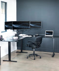 Rock Solid Corner Standing Desk Rig In Matte Black With Lightning Fast Height Adjustments And Split Tabletop Design Built For Zero Fuss Sit To Stand Moves That Totally Level Up Your Home Office with dual monitors and ergonomic chair.