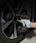 Person using impact wrench with Half Inch Drive Impact Socket Set, Nine Piece Deep Metric Sockets 29mm Through 38mm on car wheel