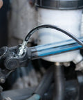 Close-up of Professional Grade 14 Oz Pistol Grip Grease Gun in use, lubricating machinery with smooth pump action.