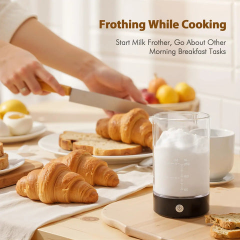 Handheld Cold Foam Frother For Coffee Battery Powered With Two AA One Button Operation on table with croissants and bread