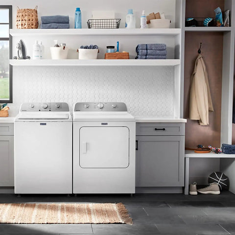 Laundry room with modern washer and dryer, storage shelves with folded towels and cleaning supplies, cozy and organized space.