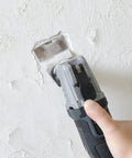 Working with Badass 20V Cordless Oscillating Multi Tool with a blade on drywall for precision detail work.