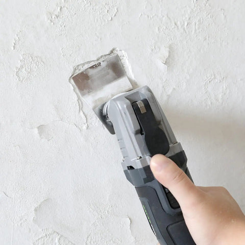 Working with Badass 20V Cordless Oscillating Multi Tool with a blade on drywall for precision detail work.