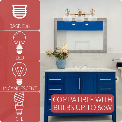 Three Light Vanity Bathroom Light With Clear Glass Shades In Warm Brass Finish above blue cabinet, compatible with bulbs up to 60W.