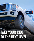 White pickup truck climbing over rocks with text 'Take Your Ride to the Next Level'