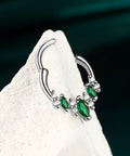 Silver septum ring with green gemstones on white background, showcasing V shape design for helix and daith piercings.