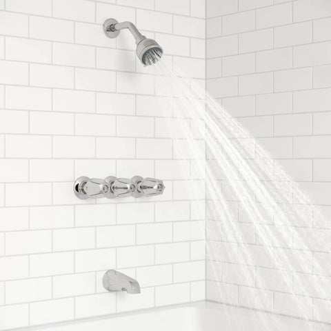 Three Handle Tub And Shower Faucet With Metal Verve Knob Handles In Polished Chrome For A Slick Bath Upgrade Includes 5 Hole Installation Valve And Cartridge Shower Arm And Flange CALGreen And CEC Water Saving installed on white tiled wall