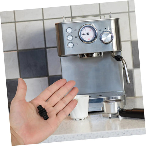 Hand holding Steam Wand Heat Shield Rubber Sleeve For Espresso Machines in front of a coffee maker showcasing the anti scald guard.