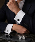 Two Pair Silver Plated French Cufflinks For Men highlighting smooth black enamel disks and crisp grid mesh patterns worn with a suit.