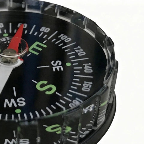 Close-up of dial on Water Resistant Hiking Compass With Lensatic Bearing Guide showing cardinal directions.