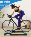 Cyclist using Whisper Quiet Indoor Bike Trainer With Foldable Stand For Road And Mountain Bikes in home gym setting