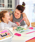 All In One Diamond Painting Tools And Accessories Storage Kit 111Pcs 5D Set in use by a woman and child, pink tool box visible