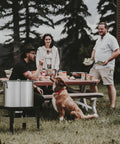 Group enjoying outdoor gathering with Seafood Boil Kit With Propane Burner And Regulator, 60 Quart Pot visible on picnic table