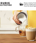 Person pouring frothed milk from standalone milk frother for non dairy milk hot and cold frothing 6 oz capacity black finish