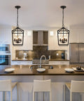 Four Light Black Farmhouse Pendant Lantern Cage Hanging Light Fixture over modern kitchen island with white cabinets