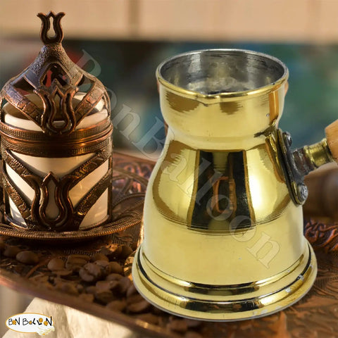Hand Hammered Brass Copper Ibrik Coffee Pot For Turkish Greek Coffee Maker With Wooden Handle 140 Ml No 3 4.73 Oz Solid Brass Decanter Cezve Jezve Turka Style For Your Daily Brew displayed on a tabletop with surrounding decor.