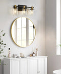 Three Light Black And Gold Bathroom Vanity Light Fixtures Over Mirror With Clear Glass Shade above round mirror