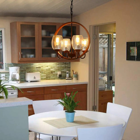 Industrial chandelier with round wood and metal design, three glass lights, hangs over kitchen dining table, rustic style.