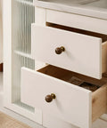 The Real Deal Natural Walnut And Antique Brass Cabinet Knobs Six Pack on white kitchen drawers, featuring round ball handles for easy use.