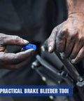 Solid Aluminum Two Piece Brake Proportioning Valve Bleeder Tool Kit For Disc And Drum Systems With Pv2 Pv4 Shuttle Valve Compatibility A No Hassle Gearhead Wrenching Workshop Essential, blue bleeder tool held in dirty hands.