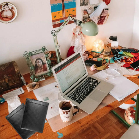 Five Pack Black Tear Resistant Bubble Pouches With Waterproof Self Adhesive Seal on a cluttered desk