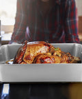 Big Turkey Roasting Pan With V Shaped Rack Stainless Steel Roaster Pan 16x11.5Inch Heavy Duty For Turkey Chicken Vegetables Lasagna Brownies Dishwasher Safe 2 Pack with a turkey in the oven