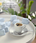 12 Breville BWF100-compatible charcoal water filters, light blue tablets, on a white tray beside an espresso cup