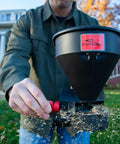 Person using Five Pound All Season Handheld Spreader With Easy Fill Design For Seed Ice Melt And Fertilizer Perfect For Sidewalks Yards