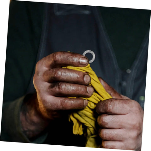 Top Shelf Tapered Lock Washers For M10 Manganese Steel 20 Pack held in dirty hands with a yellow cloth for grip.
