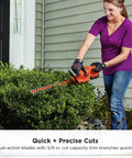 Person using 20V Max Hedge Trimmer Kit with 18 Inch Blade for quick yard cleanup on bushes. Dual action hardened steel blades.