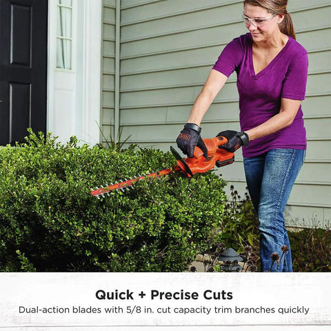 Person using 20V Max Hedge Trimmer Kit with 18 Inch Blade for quick yard cleanup on bushes. Dual action hardened steel blades.