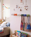 Set of Six Playful Ceramic Wall Hooks for Coats and Keys Game Changer Storage Solution Sweet Decorative Hangers Assorted Colors mounted in a child's room.